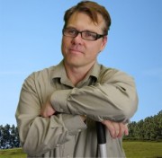 Man with brown hair and dark-rimmed glasses